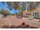 Expansive backyard featuring desert landscaping, mature trees, and a covered patio area perfect for outdoor dining at 4542 Amber Canyon Ln, Las Vegas, NV 89129