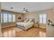 Bright bedroom showcasing laminate floors, ceiling fan, plantation shutters, and neutral paint at 4542 Amber Canyon Ln, Las Vegas, NV 89129