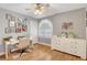 Bright bedroom with hardwood floors, a ceiling fan, an arched window, and a work desk at 4542 Amber Canyon Ln, Las Vegas, NV 89129