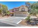 Inviting two-story home showcasing a three-car garage,tile roof, and desert landscaping at 4542 Amber Canyon Ln, Las Vegas, NV 89129