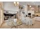 Bright, open kitchen featuring white cabinets, granite countertops, and a clear glass breakfast table at 4542 Amber Canyon Ln, Las Vegas, NV 89129