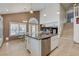 Open kitchen featuring a granite island, white cabinetry, stainless dishwasher and adjacent breakfast area at 4542 Amber Canyon Ln, Las Vegas, NV 89129