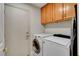 Convenient laundry room featuring a washer, dryer, and upper cabinets at 4542 Amber Canyon Ln, Las Vegas, NV 89129