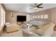 Comfortable living room showcasing a sectional sofa, ceiling fan, and neutral color palette at 4542 Amber Canyon Ln, Las Vegas, NV 89129