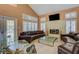 Inviting living room featuring vaulted ceilings, fireplace, tiled floors, and modern decor at 4542 Amber Canyon Ln, Las Vegas, NV 89129