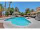 Sparkling pool and spa surrounded by lush landscaping, palm trees, and a covered outdoor living space at 4542 Amber Canyon Ln, Las Vegas, NV 89129