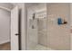 Walk-in shower with clear glass doors, grey tile, rain shower head, and open white door at 4542 Amber Canyon Ln, Las Vegas, NV 89129
