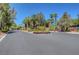 Community street featuring mature trees, lush landscaping, and the community's entrance sign at 4542 Amber Canyon Ln, Las Vegas, NV 89129