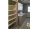 Bright laundry room featuring washer/dryer, utility sink, built-in shelving, and exterior access at 462 Crestway Rd, Henderson, NV 89015