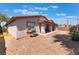 Rear exterior view features a graveled backyard, covered patio, desert landscaping, and stucco siding at 4656 E Desert Inn Rd, Las Vegas, NV 89121