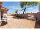 Gravel-covered backyard features a brick perimeter wall and mature trees at 4656 E Desert Inn Rd, Las Vegas, NV 89121
