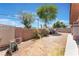 Low maintenance backyard with gravel, mature shade trees, and a block wall fence for privacy at 4656 E Desert Inn Rd, Las Vegas, NV 89121