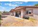 Exterior of home displaying back covered patio, graveled yard, desert landscaping, and stucco siding at 4656 E Desert Inn Rd, Las Vegas, NV 89121