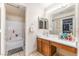 Bright bathroom featuring a single sink vanity, large mirror, and shower-tub combination at 4656 E Desert Inn Rd, Las Vegas, NV 89121