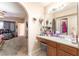Bathroom with wood cabinets, a mirror and view of the bedroom at 4656 E Desert Inn Rd, Las Vegas, NV 89121