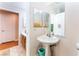 A bathroom with a pedestal sink, mirror, and a toilet, with access to another room at 4656 E Desert Inn Rd, Las Vegas, NV 89121