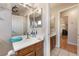 Bathroom featuring a single vanity, large mirror, and doorway to hallway at 4656 E Desert Inn Rd, Las Vegas, NV 89121
