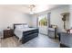 Comfortable bedroom featuring gray wood-look flooring, a ceiling fan and a window with natural light at 4656 E Desert Inn Rd, Las Vegas, NV 89121