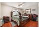 Bedroom featuring wood floors, ceiling fan, and decorative headboard with matching nightstands at 4656 E Desert Inn Rd, Las Vegas, NV 89121