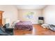 A bright bedroom showcasing wood-look floors, a comfortable bed, and a window for natural light at 4656 E Desert Inn Rd, Las Vegas, NV 89121