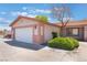 Attached two-car garage with an adjacent landscaped area at 4656 E Desert Inn Rd, Las Vegas, NV 89121