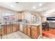 Open kitchen with view of living room, wood cabinets, white appliances, and tile floors at 4656 E Desert Inn Rd, Las Vegas, NV 89121