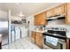 Kitchen area with stainless steel oven and range, wood cabinets, and white appliances at 4656 E Desert Inn Rd, Las Vegas, NV 89121