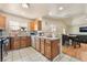 Open kitchen with wood cabinets, white appliances, and bar seating connected to the dining area at 4656 E Desert Inn Rd, Las Vegas, NV 89121