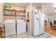Functional laundry area with washer, dryer, shelving, and tile flooring near the kitchen and hardwood flooring at 4656 E Desert Inn Rd, Las Vegas, NV 89121