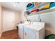 Functional laundry room featuring a washer, dryer, utility sink and storage shelves for supplies at 4656 E Desert Inn Rd, Las Vegas, NV 89121