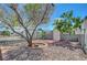Unique drought tolerant landscaped front yard featuring decorative rock, brick accents, a mature tree and perimeter fencing with a gate at 4807 Sacks Dr, Las Vegas, NV 89122