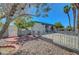 Well-maintained front yard featuring decorative rock, small brick accents, a mature tree, and decorative fencing with a gate at 4807 Sacks Dr, Las Vegas, NV 89122