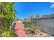 The side yard has a brick path with decorative rock and varied greenery at 4807 Sacks Dr, Las Vegas, NV 89122