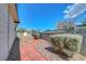 Landscaped side yard featuring a red brick pathway and mature bushes at 4807 Sacks Dr, Las Vegas, NV 89122