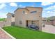 Spacious backyard featuring artificial turf, a patio with seating, and block wall fencing at 4833 Royal Magnolia St, North Las Vegas, NV 89031