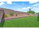 Well-maintained backyard with green artificial turf, brick walls, and landscaping at 4833 Royal Magnolia St, North Las Vegas, NV 89031