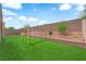 Lush backyard featuring artificial turf, landscaping and a swing set at 4833 Royal Magnolia St, North Las Vegas, NV 89031