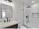 This bathroom features a shower and tub combo, marble sink, a mirror and modern lighting at 4911 Ranchodomingo Ct, North Las Vegas, NV 89031