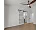 Bedroom featuring a sliding barn door and hardwood flooring at 4911 Ranchodomingo Ct, North Las Vegas, NV 89031