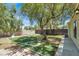 Backyard featuring well-maintained artificial turf with a unique 'C' design and mature trees, creating a private outdoor space at 5008 Donnie Ave, Las Vegas, NV 89130