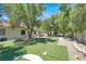 Spacious backyard featuring artificial turf, mature trees, and a patio area, perfect for outdoor living and entertaining at 5008 Donnie Ave, Las Vegas, NV 89130