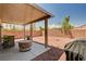 Spacious backyard with covered patio, gravel landscaping, and privacy wall at 5220 Melbourne Ridge Ct, Las Vegas, NV 89141
