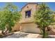 Two-story home with a two-car garage and landscaping that includes small trees and green shrubs at 5220 Melbourne Ridge Ct, Las Vegas, NV 89141