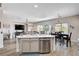 Open-concept kitchen with stainless steel appliances, an island, and a seamless flow to the living and dining area at 5220 Melbourne Ridge Ct, Las Vegas, NV 89141