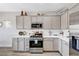 Modern kitchen with stainless steel appliances, gray cabinets, and white countertops, creating a clean and stylish cooking space at 5220 Melbourne Ridge Ct, Las Vegas, NV 89141