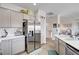 Bright kitchen with stainless steel refrigerator, light countertops, and view to staircase and living space at 5220 Melbourne Ridge Ct, Las Vegas, NV 89141