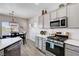 Bright kitchen featuring stainless steel appliances, light gray cabinets, and a view into the dining area at 5220 Melbourne Ridge Ct, Las Vegas, NV 89141