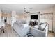 Bright living room with light gray sofas, modern decor, and wood flooring, creating a welcoming and comfortable space at 5220 Melbourne Ridge Ct, Las Vegas, NV 89141