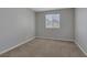 Cozy bedroom with neutral walls, plush carpeting, and a window overlooking the neighborhood at 5484 Mercury Springs Dr, Las Vegas, NV 89122