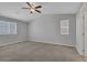 Spacious bedroom features neutral carpet, natural light, and a ceiling fan at 5484 Mercury Springs Dr, Las Vegas, NV 89122
